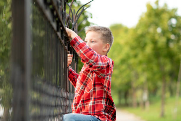 istock The boy climbed the forged fence. 1200405516