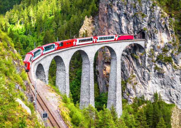 landwasser viaduct in filisur, switzerland. it is landmark of swiss alps. bernina express train on railroad bridge in mountains. aerial scenic view of famous railway. - bernina express imagens e fotografias de stock