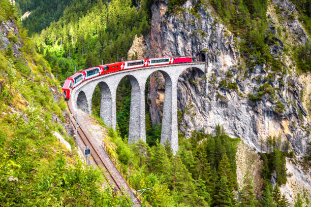 landwasser viaduct in summer, filisur, switzerland. it is landmark of swiss alps. nice alpine landscape. red train of bernina express on railroad bridge in mountains. - bernina express imagens e fotografias de stock