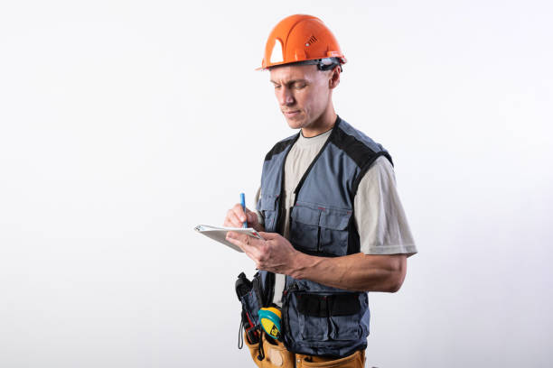 Builder with a notepad. In a helmet and a robe. Writes data. stock photo