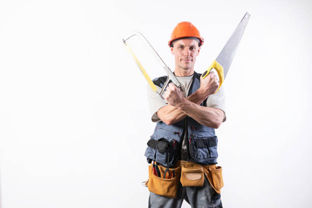 istock A builder with hacksaw in a helmet, smiling. On a light background. 1200413059