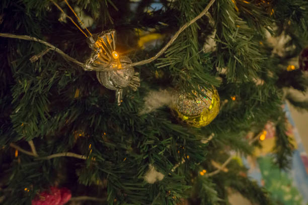 istock Closeup of red bauble hanging from a decorated Christmas tree. Retro filter effect. 1200417473