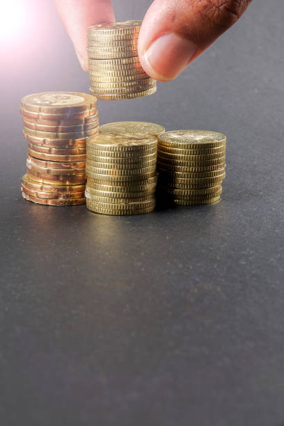 istock Hand put coins to stack of coins on black background 1200419701