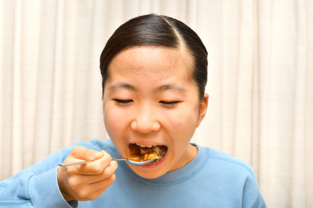 istock Japanese girl enjoys having curry and rice 1200425687