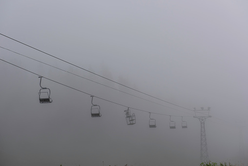 ski lift in the forest, and moody fog