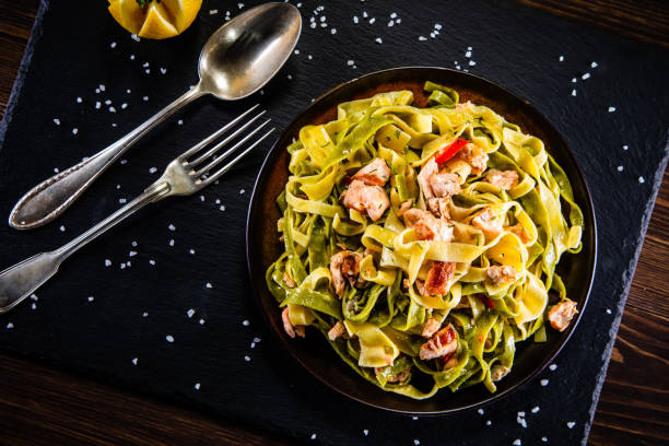 istock Pasta with salmon and vegetables on wooden background 1200426596