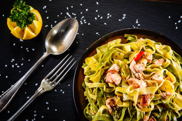 istock Pasta with salmon and vegetables on wooden background 1200426632
