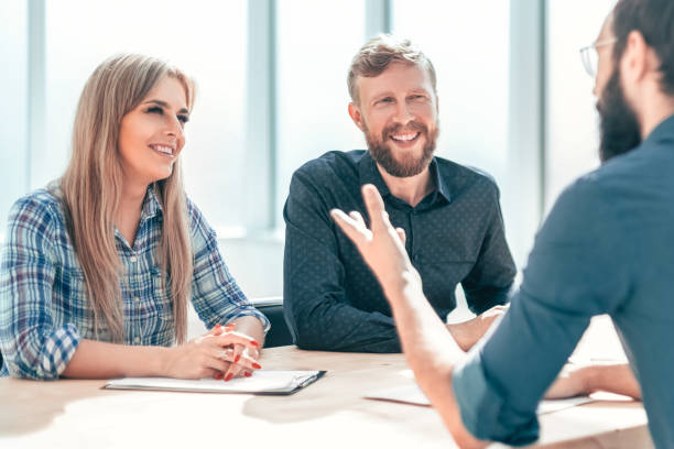 istock group of business people sitting at the office table. 1200431287