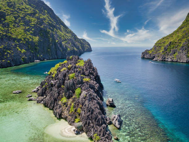Tapiutan Island Palawan Beach Islet Hut El Nido Philippines Drone view to Tapiutan Island Islet with a lonely handmade robinson-like beach hut in front of a rocky cliff on remote islet close to Tapiutan Island, El Nido, Palawan, Southern Tagalog Region, Philippines, Asia el nido photos stock pictures, royalty-free photos & images
