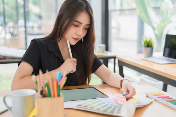 istock Beautiful young freelance graphic designer choosing color samples for designing mobile application screens layout at modern office. 1200441626