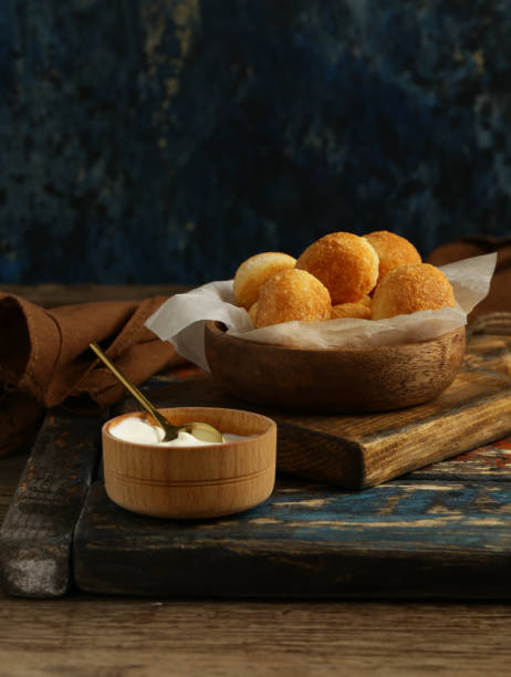 Premium Photo  Cheese balls with garlic and dill inside for a snack in a  plate on a black background