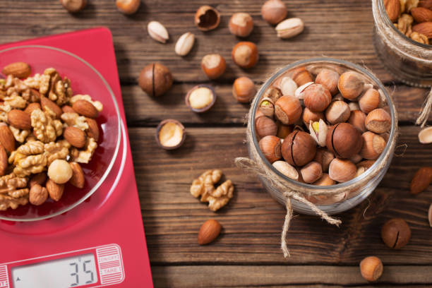 istock mix of different nuts on  kitchen scale on old wooden background 1200444645