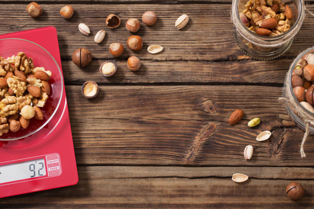 istock mix of different nuts on  kitchen scale on old wooden background 1200444646