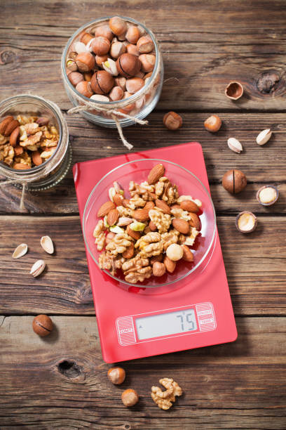 istock mix of different nuts on  kitchen scale on old wooden background 1200444650