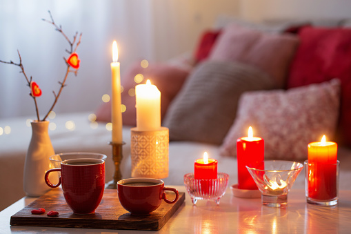 Burning candles on white table in interior. Valentines day concept