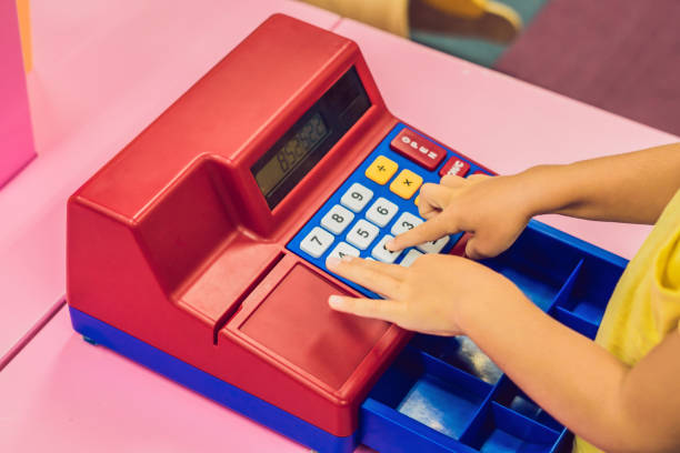 el niño juega con la caja registradora de los niños - cash register coin cash box checkout counter fotografías e imágenes de stock