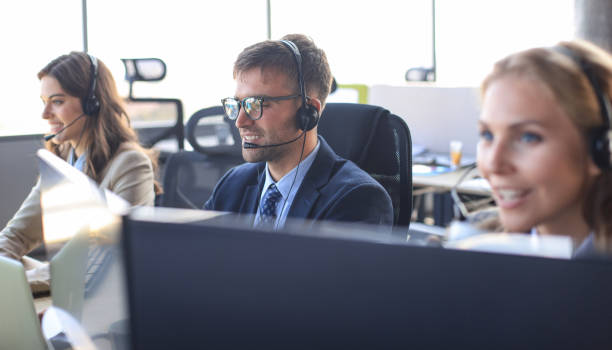 istock Portrait of call center worker accompanied by his team. Smiling customer support operator at work. 1200450678