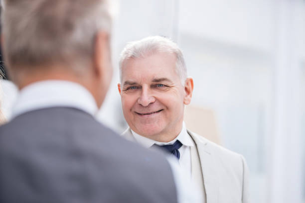istock close up. two business men talking in the office. 1200450973