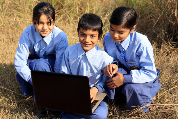 istock Elementary age school children using laptop outdoor in nature 1200452767