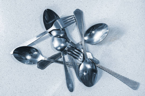 istock Set of metal spoons and forks randomly scattered on the table 1200452995