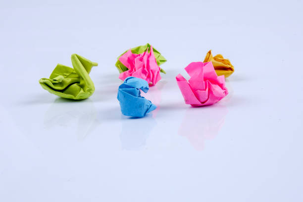 istock Colourful crumpled paper ball on a whiteboard. Close up. 1200453168