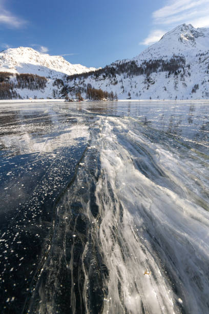 수중으로 채워진 큰 얼음 균열과 얼어 붙은 호수 표면에 다시 얼어 붙습니다. - engadin valley cloud sky lake 뉴스 사진 이미지