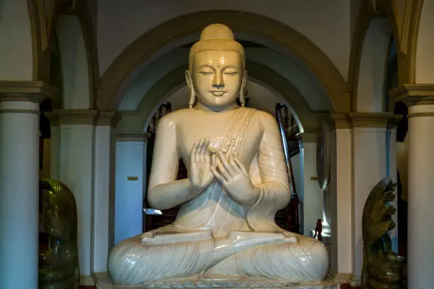 Photo of Buddha statue inside of the Sri Dalada Maligawa or the Temple of the Sacred Tooth Relic, a Buddhist temple in the city of Kandy, Sri Lanka. which houses the relic of the tooth of the Buddha.