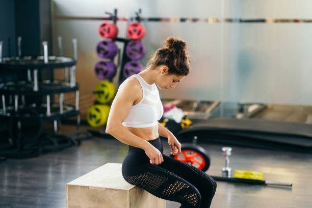 istock Athletic woman doing squats on box at the gym 1200455253