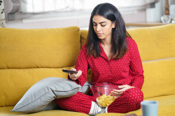 istock Persian woman at home watching TV and using remote control 1200455407
