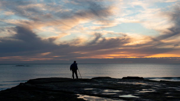 istock Photographer at Muriwai beach at sunset 1200460509