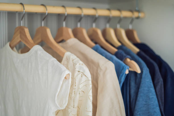 istock Clothes on hangers in the cabinet gradient from white to dark blue 1200460888