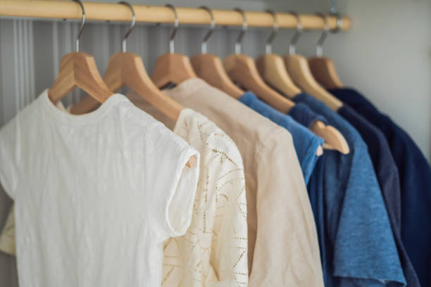 istock Clothes on hangers in the cabinet gradient from white to dark blue 1200460890
