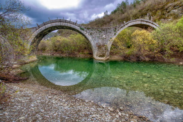 The old stone three arch bridge of Plakida or Kalogeriko, Zagori, Ioannina in Epirus Greece The old historical and traditional stone three arch bridge of Plakida or Kalogeriko near Kipoi Greek village of Zagori at the region of Ioannina in Epirus Greece zagori stock pictures, royalty-free photos & images
