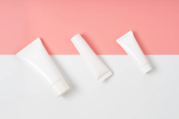 istock Cream product on pink and white  background 1200463394