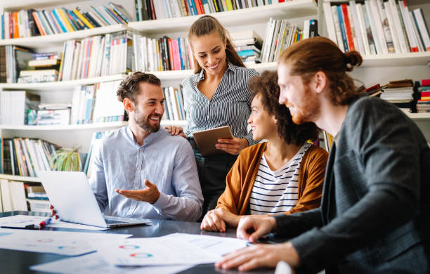 istock Working together on project. Happy young business colleagues working in office 1200464755