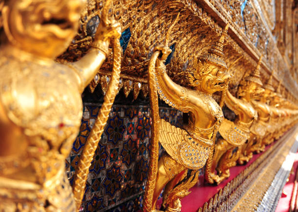 garudas et nagas sur les décorations extérieures de l'ubosoth wat phra kaew temple grand palace bangkok thaïlande. - garuda bangkok thailand gold photos et images de collection