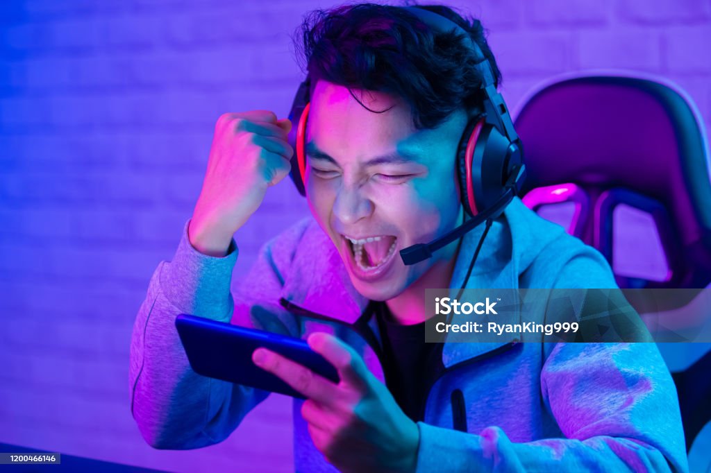 cybersport gamer win the game cybersport gamer win the game and cheer with fist gesture Gamer Stock Photo