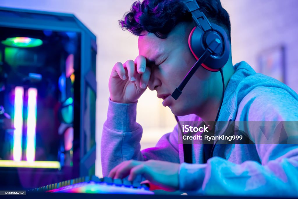 asian gamer has eyes pain Young asian esport gamer feel painful while playing in Online Video Game because his eye is tired Video Game Stock Photo