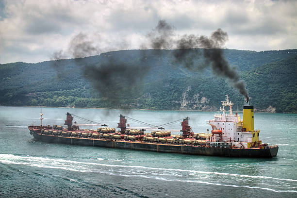 Polluting vessel Heavy industry transport ship with oil trucks mounted on top ship funnel stock pictures, royalty-free photos & images