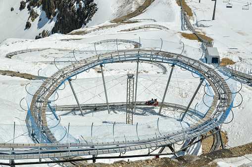 Glacier 3000, Switzerland - June 8, 2019: People riding on the toboggan on top station on Glacier 3000  in canton of Vaud, Switzerland during June 2019