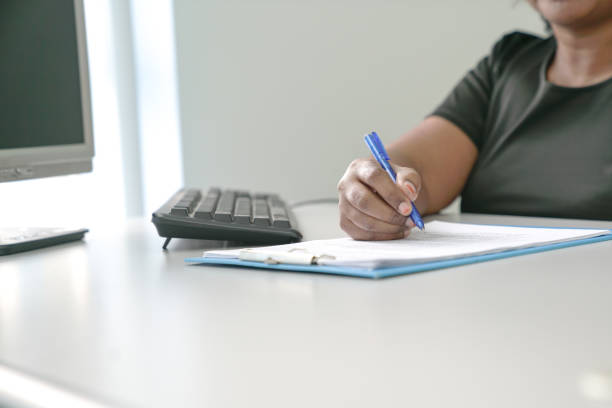 istock Businesswoman or manager writing on document at her office desk 1200474992