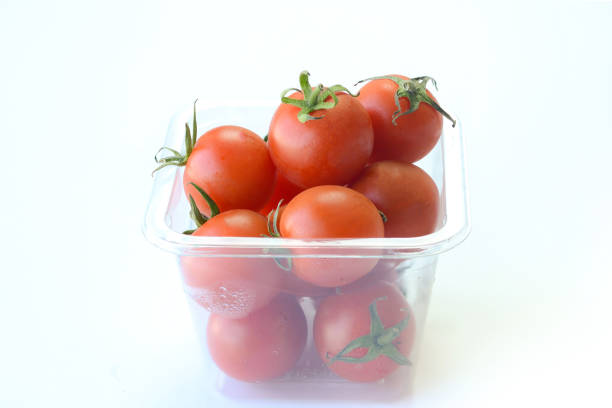 Stock photo showing close-up view of three whole tomatoes on a red background, healthy eating poster wallpaper background design.