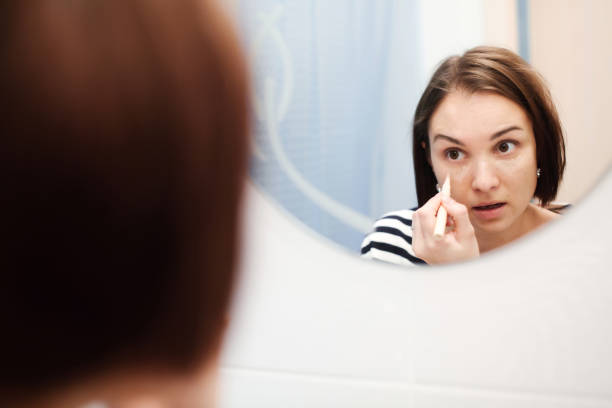 istock Young brunette woman using concealer for under eye circles 1200476822