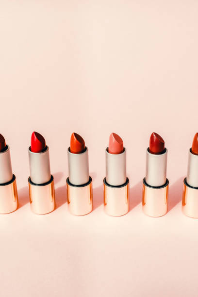 istock Multi-colored lipsticks stand in a row on a pink background. The concept of different, collections and beauty. Red, pink and burgundy lipsticks 1200479802