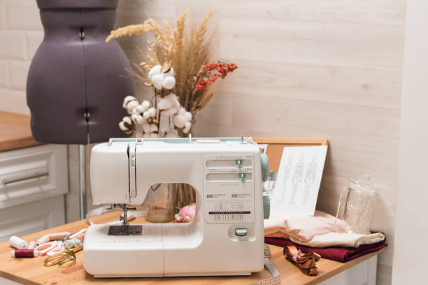 istock The workplace of a seamstress. Sewing machine on the table, thread, scissors and mannequin 1200479961
