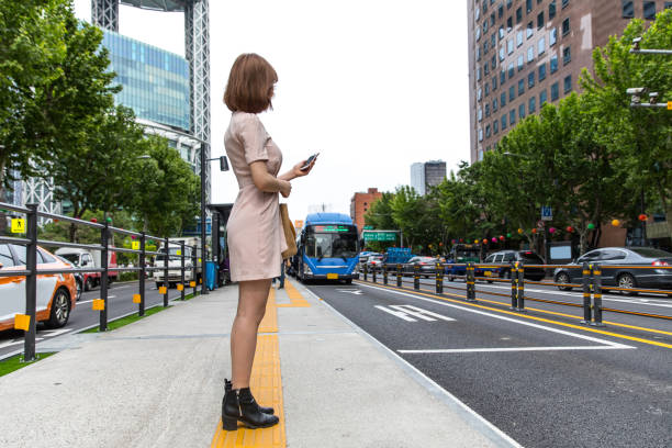 istock Young woman waiting at bus stop her connection to going at work 1200481096