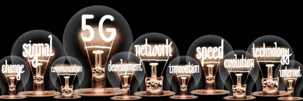 Large group of shining light bulbs with fibers in a shape of 5G, Signal, Network, Speed and Technology isolated on black background; concept of mobile network change