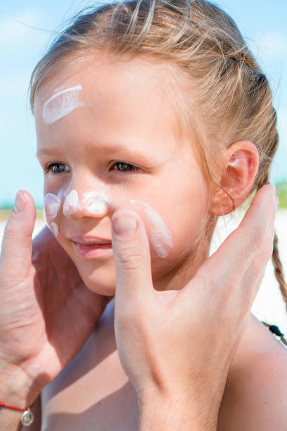 istock Father applying sun cream to daughter nose. 1200484002