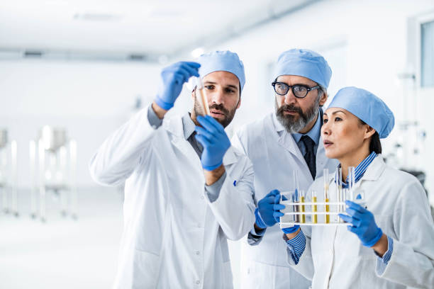 istock Team of biochemists cooperating while examining essential oil in tubes at laboratory. 1200486908