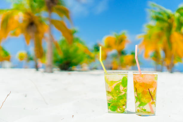 istock Two tasty cocktails on tropical white beach 1200488243